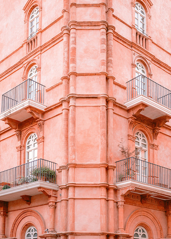 Cuadro de ciudades con fachada rosada y balcones